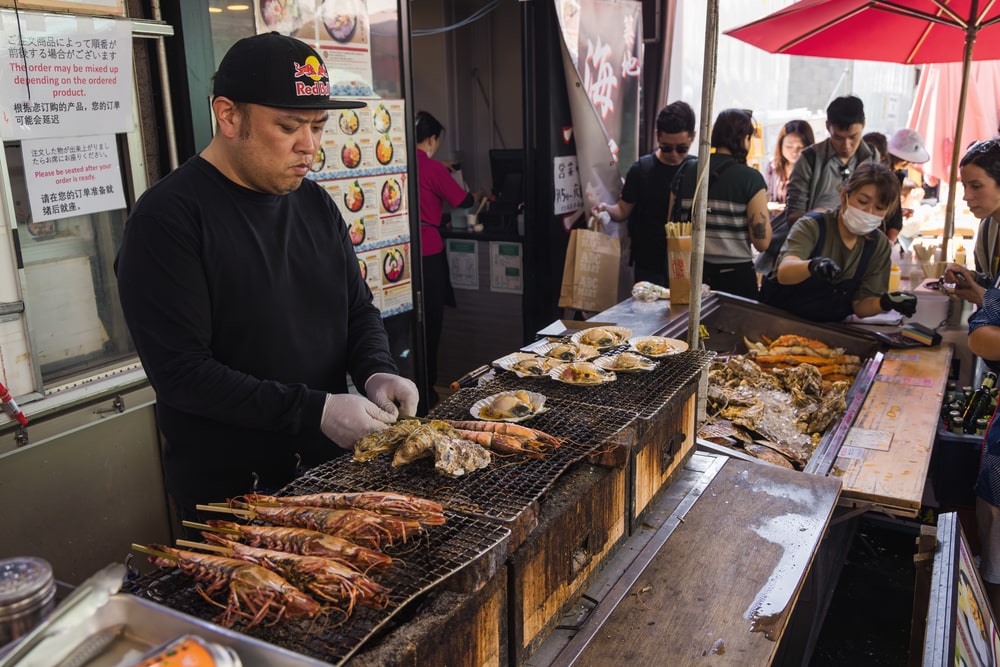 Tsukiji market man grlling breakfast on tour